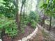 Peaceful backyard path and stone retaining wall showcasing the natural beauty of the home's outdoor space at 3015 Hamptonbrook Dr, Gastonia, NC 28056