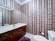 Well-lit bathroom with vanity, toilet, and patterned wallpaper at 3015 Hamptonbrook Dr, Gastonia, NC 28056