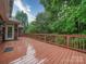 Outdoor deck with wooden planks and railings surrounded by trees at 3015 Hamptonbrook Dr, Gastonia, NC 28056
