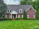 Charming red brick home with manicured lawn, mature trees and dormer windows provides excellent curb appeal at 3015 Hamptonbrook Dr, Gastonia, NC 28056