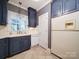 Blue cabinetry with white appliances and checkered wallpaper at 3015 Hamptonbrook Dr, Gastonia, NC 28056