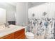 Traditional bathroom with a wooden vanity and a shower/tub combination with a floral curtain at 31470 Royal Tern Ln, Indian Land, SC 29707