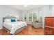 Inviting bedroom with hardwood floors, neutral color scheme, and natural light from bright windows at 31470 Royal Tern Ln, Indian Land, SC 29707