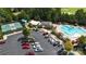 Aerial view of a community pool area surrounded by lounge chairs, parking and mature trees at 31470 Royal Tern Ln, Indian Land, SC 29707