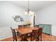 Inviting dining room with a wooden table set for six, a stylish light fixture, and hardwood floors at 31470 Royal Tern Ln, Indian Land, SC 29707