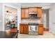 Kitchen showcases stainless steel appliances, wood cabinetry, and an open view to the living area at 31470 Royal Tern Ln, Indian Land, SC 29707