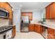 Well-lit kitchen featuring stainless steel appliances, tile floors, and wood cabinets at 31470 Royal Tern Ln, Indian Land, SC 29707