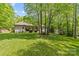 Rear view of the home with a well-manicured backyard, patio, and storage shed at 4025 Cherrybrook Dr, Mint Hill, NC 28227