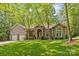 Stunning brick home featuring a two-car garage, mature trees, and manicured lawn at 4025 Cherrybrook Dr, Mint Hill, NC 28227