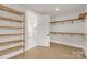 Spacious walk-in closet with wooden shelving with an open door to a white tiled bathroom at 4095 Kingfisher Dr, York, SC 29745