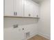 White cabinets in the laundry room offer storage space, keeping the area tidy and organized at 4095 Kingfisher Dr, York, SC 29745