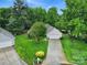 An elevated view of a cozy home with mature trees, landscaping, and a paved driveway on a cul-de-sac at 5009 Ravens Ct, Matthews, NC 28104