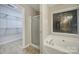 Well-lit bathroom featuring a shower stall, soaking tub under a window, and a view into a large closet at 5009 Ravens Ct, Matthews, NC 28104