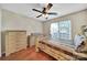 Cozy bedroom with a ceiling fan, wood floors, and natural light from a bright window at 5009 Ravens Ct, Matthews, NC 28104
