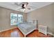 Bedroom features hardwood floors, ceiling fan, double windows, and a white dresser at 5009 Ravens Ct, Matthews, NC 28104