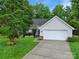 Charming single-Gathering home features a well-manicured lawn and a two-car garage with a paved driveway at 5009 Ravens Ct, Matthews, NC 28104