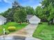 Charming single-Gathering home featuring a well-manicured lawn and a two-car garage with a paved driveway at 5009 Ravens Ct, Matthews, NC 28104