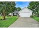 A beautiful home featuring a well-manicured lawn and a two-car garage with a paved driveway at 5009 Ravens Ct, Matthews, NC 28104