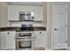 Well-equipped kitchen featuring stainless steel double oven, granite counters, and white cabinets at 5009 Ravens Ct, Matthews, NC 28104