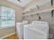 Bright laundry room with a window, washer, dryer, and ample shelving at 5009 Ravens Ct, Matthews, NC 28104