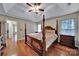 Spacious main bedroom features hardwood floors, a four-post bed, and a ceiling fan at 5009 Ravens Ct, Matthews, NC 28104