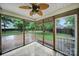 Cozy sunroom featuring a ceiling fan, access door, and views of the backyard through multiple windows at 5009 Ravens Ct, Matthews, NC 28104