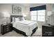 Well-lit bedroom featuring neutral decor, a comfortable bed, and a dark wood dresser at 5030 Grain Orchard Rd # 3025C, Indian Trail, NC 28079