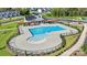 Aerial view of a community pool with lounge chairs and a splash pad surrounded by greenery at 5030 Grain Orchard Rd # 3025C, Indian Trail, NC 28079