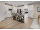 Bright kitchen featuring white cabinetry, stainless appliances, an island with seating, and wood-look floors at 523 Lenswood Ct, Denver, NC 28037