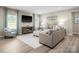 Cozy living room features a gray sectional, soft armchair, and large windows with stylish curtains at 523 Lenswood Ct, Denver, NC 28037