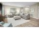 Inviting living room with gray sofas, a soft ottoman, light-colored walls, and wood-look floors at 523 Lenswood Ct, Denver, NC 28037