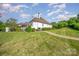 Lush green lawn in backyard, framed by mature landscaping and a brick walkway, enhances the property's charm at 5400 Challisford Ln, Charlotte, NC 28226
