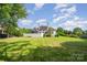 Expansive backyard with lush green lawn, mature trees, and an inviting atmosphere at 5400 Challisford Ln, Charlotte, NC 28226