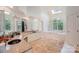 Large bathroom with dual sinks, granite countertops, a skylight, a soaking tub, and tiled flooring at 5400 Challisford Ln, Charlotte, NC 28226
