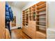 Walk-in closet with custom built-in wood shelving and drawers for optimal storage at 5400 Challisford Ln, Charlotte, NC 28226