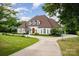 Elegant home featuring a circular driveway, arched entry, and manicured lawn, framed by mature landscaping at 5400 Challisford Ln, Charlotte, NC 28226