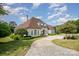 Elegant home featuring a circular driveway, lush landscaping, and architectural charm, surrounded by mature trees at 5400 Challisford Ln, Charlotte, NC 28226