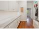 Bright hallway featuring built-in white cabinets, hardwood floors, and access to other rooms at 5400 Challisford Ln, Charlotte, NC 28226