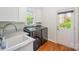 Bright laundry room with black washer and dryer, white cabinets and a door to the backyard at 5400 Challisford Ln, Charlotte, NC 28226