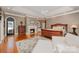 Luxurious main bedroom featuring a fireplace, sitting area, and a large bed on hardwood floors at 5400 Challisford Ln, Charlotte, NC 28226