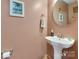 Stylish half bathroom featuring a pedestal sink, decorative mirror, and elegant fixtures at 544 Cool Creek Dr, Rock Hill, SC 29732