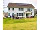 Large backyard with a patio, string lights, and solar panels on the roof, perfect for outdoor living at 6016 Willow Pin Ln, Huntersville, NC 28078