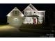Beautiful two-story home featuring a well-lit exterior, charming porch, and a manicured front lawn at 6016 Willow Pin Ln, Huntersville, NC 28078