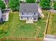 Aerial view of a spacious, green backyard with a small patio and wood fence surrounding the property at 6541 Hasley Woods Dr, Huntersville, NC 28078