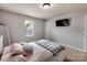 Cozy bedroom featuring a wall-mounted TV, a window, carpeted floors, and natural light at 6541 Hasley Woods Dr, Huntersville, NC 28078