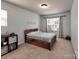 Light and airy bedroom with neutral walls, carpet, and window overlooking backyard at 6541 Hasley Woods Dr, Huntersville, NC 28078