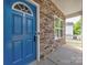 A close-up shot of a bright blue front door with stone and light grey vinyl siding at 6541 Hasley Woods Dr, Huntersville, NC 28078