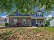 Charming two-story home with a stone facade, blue shutters, and manicured lawn at 6541 Hasley Woods Dr, Huntersville, NC 28078
