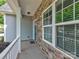 A welcoming front porch featuring stone detailing, white pillars, and an exterior view of the neighborhood at 6541 Hasley Woods Dr, Huntersville, NC 28078