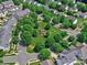 Aerial view of a community park featuring mature trees, green space, sidewalks, and benches in a residential area at 6541 Hasley Woods Dr, Huntersville, NC 28078